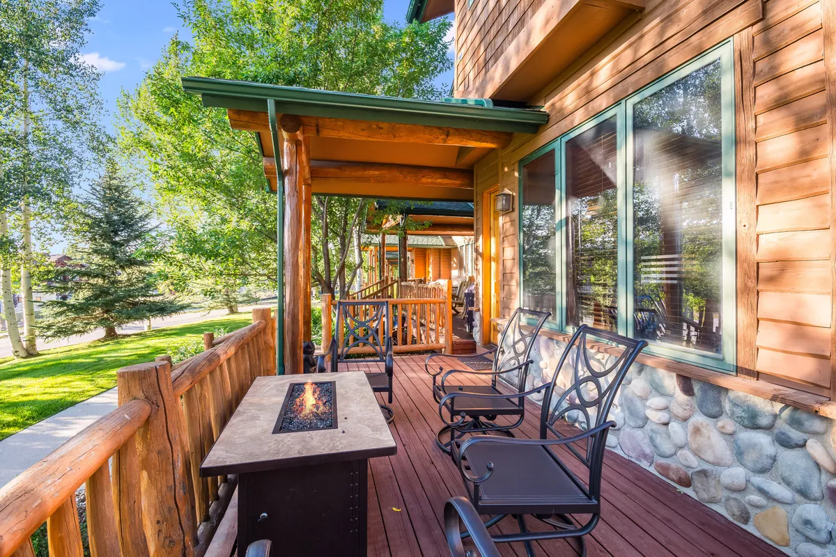 An outdoor gathering area with a fire pit, comfortable seating, and a wooden railing offers a cozy spot for relaxing or entertaining under the open sky. The scene hints at stargazing and enjoying cool mountain evenings together.